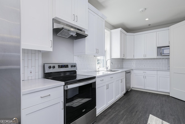 kitchen with stainless steel appliances, dark wood-type flooring, white cabinets, backsplash, and sink