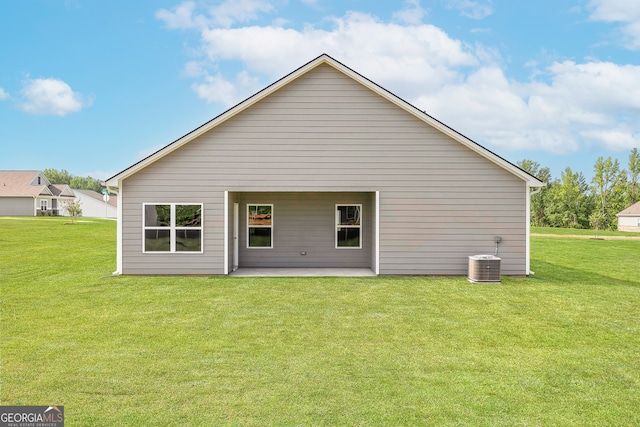 back of property with cooling unit, a patio area, and a yard