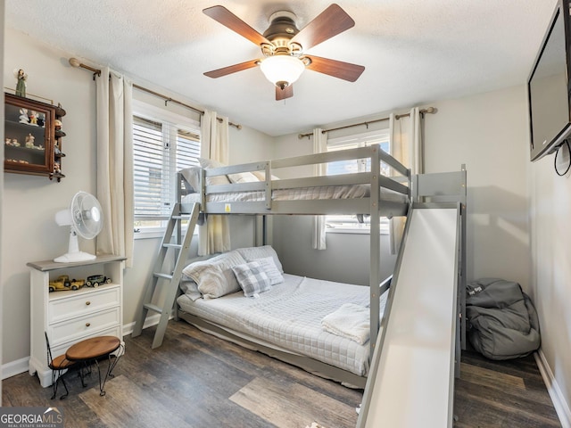 bedroom with dark hardwood / wood-style flooring, a textured ceiling, and ceiling fan