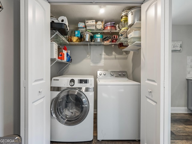 laundry area with dark hardwood / wood-style floors and washer and clothes dryer