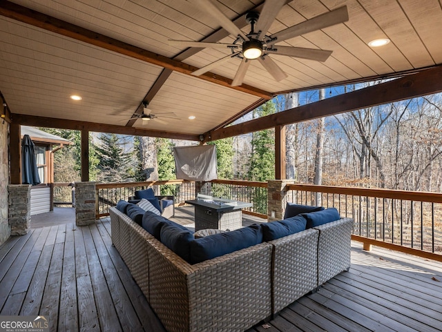 wooden deck with an outdoor living space with a fire pit and ceiling fan