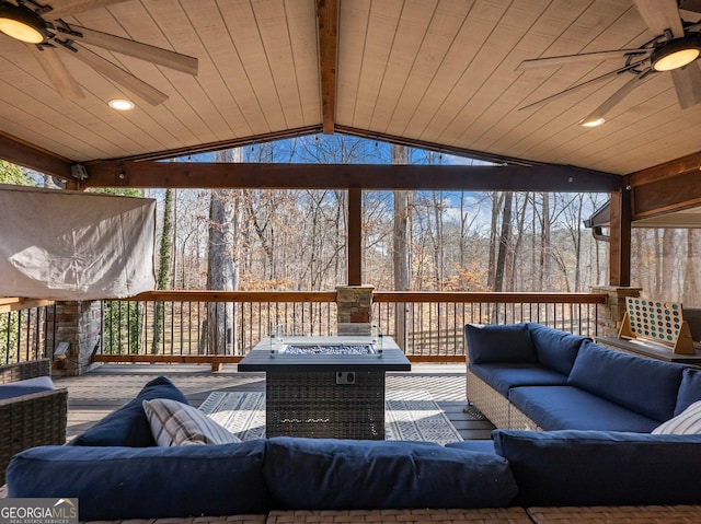 wooden terrace with an outdoor living space with a fire pit and ceiling fan