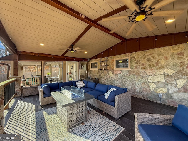 wooden terrace featuring ceiling fan and an outdoor living space with a fire pit