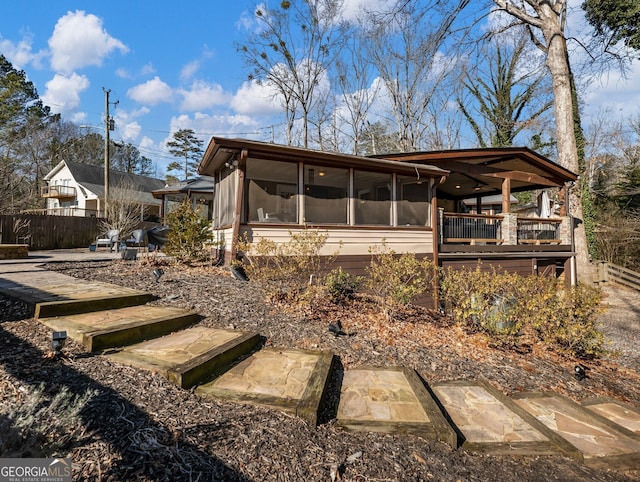 rear view of house featuring a sunroom