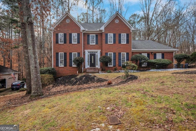 colonial-style house featuring a front lawn