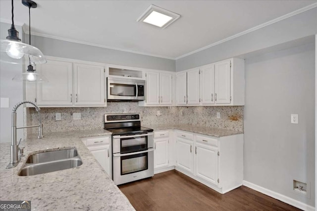 kitchen with light stone counters, decorative light fixtures, white cabinets, appliances with stainless steel finishes, and sink