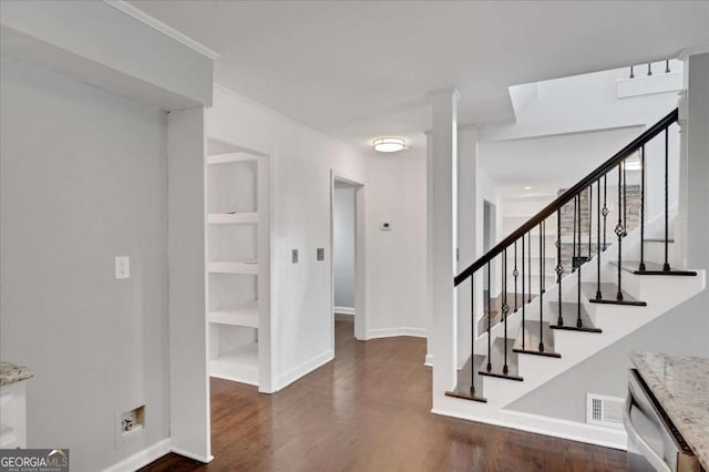 staircase with hardwood / wood-style flooring, built in features, and ornamental molding