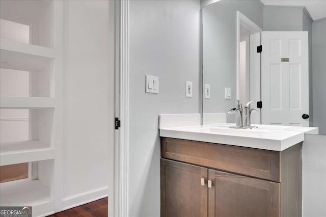 bathroom featuring vanity, hardwood / wood-style flooring, and built in shelves