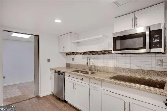 kitchen featuring appliances with stainless steel finishes, light wood-type flooring, white cabinets, and sink