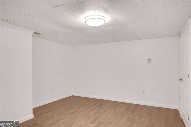 unfurnished room with a paneled ceiling and wood-type flooring