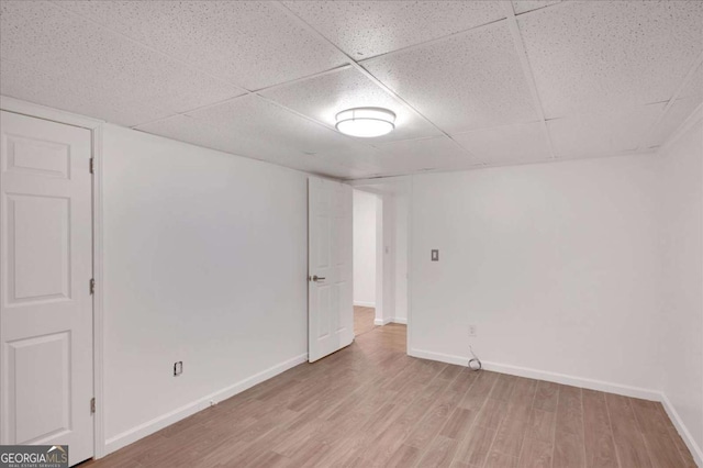 empty room featuring a drop ceiling and wood-type flooring