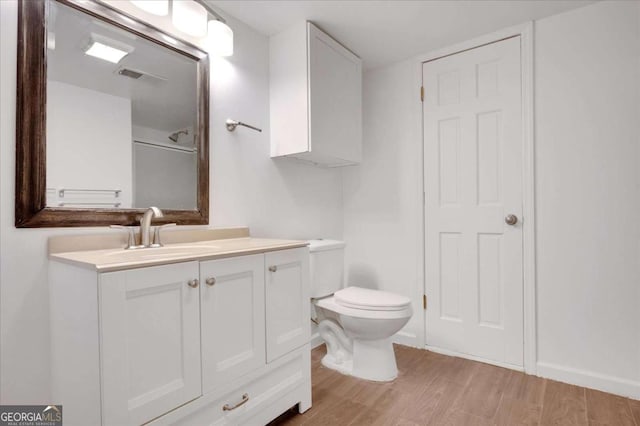 bathroom featuring toilet, wood-type flooring, and vanity