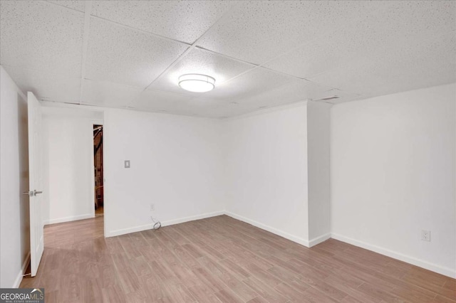 unfurnished room with wood-type flooring and a drop ceiling