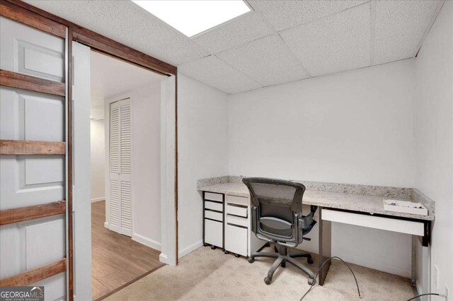 carpeted office space with a drop ceiling