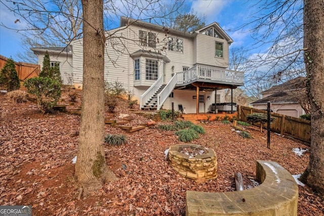 rear view of house with a fire pit and a deck