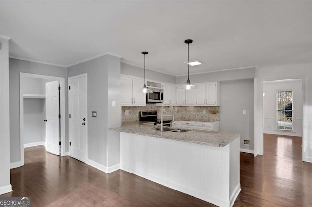 kitchen featuring appliances with stainless steel finishes, tasteful backsplash, white cabinets, and kitchen peninsula