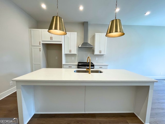 kitchen with white cabinetry, an island with sink, and wall chimney exhaust hood