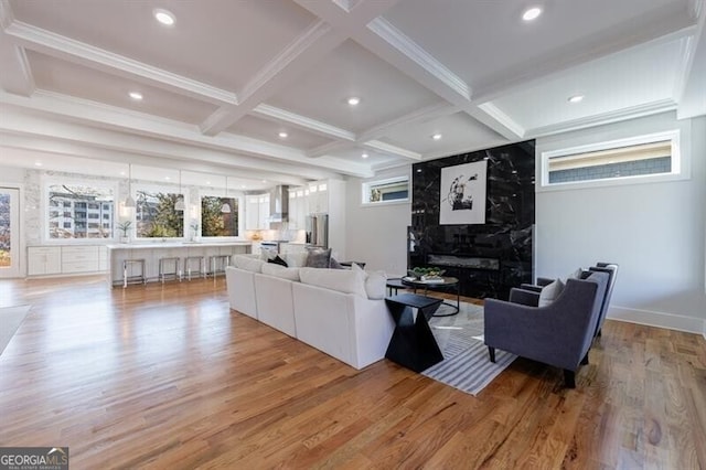 living room with light wood-type flooring, beam ceiling, and coffered ceiling