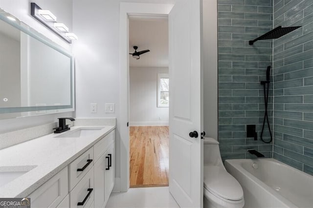 full bathroom featuring hardwood / wood-style floors, toilet, vanity, and tiled shower / bath