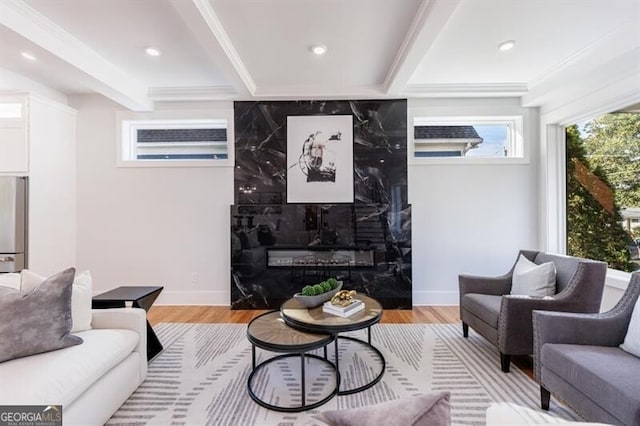 living room featuring a wall unit AC, light wood-type flooring, crown molding, and beam ceiling