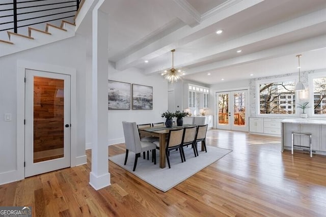 dining space with beam ceiling, french doors, and light hardwood / wood-style flooring