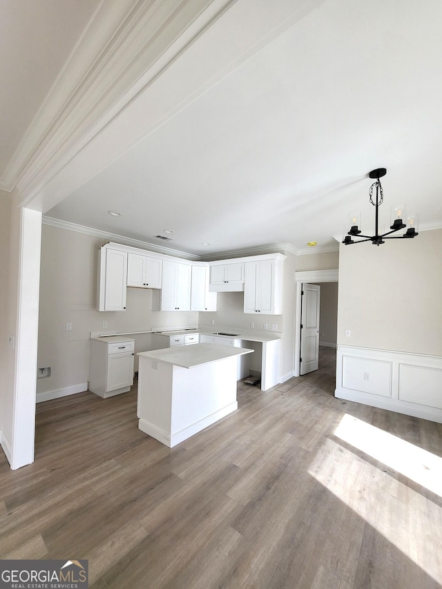 kitchen featuring light wood-style floors, a center island, white cabinets, and crown molding