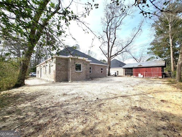 exterior space featuring an outbuilding, a pole building, and brick siding