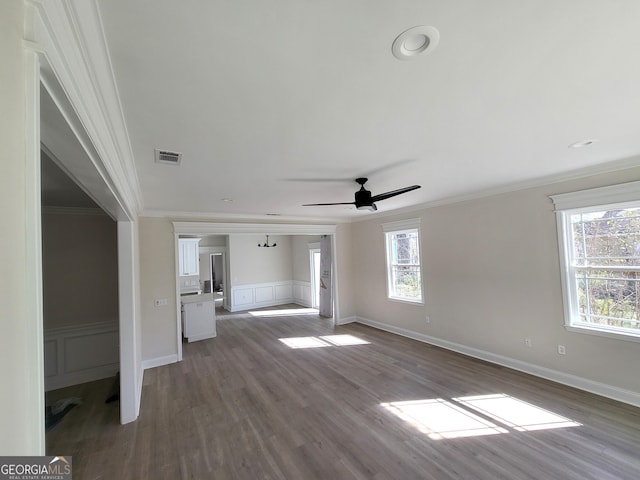 unfurnished living room with ornamental molding, dark wood finished floors, and a decorative wall