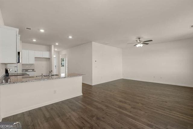 kitchen with sink, white cabinetry, dark hardwood / wood-style floors, and light stone countertops