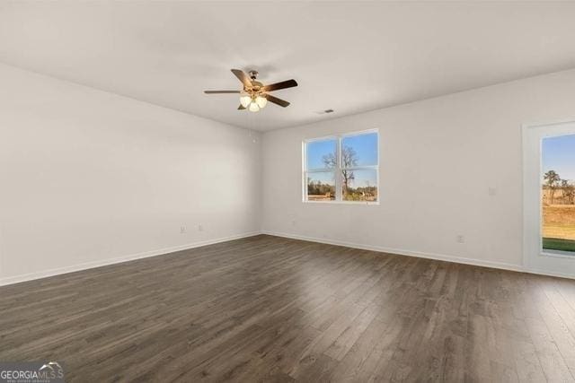 unfurnished room featuring ceiling fan and dark wood-type flooring