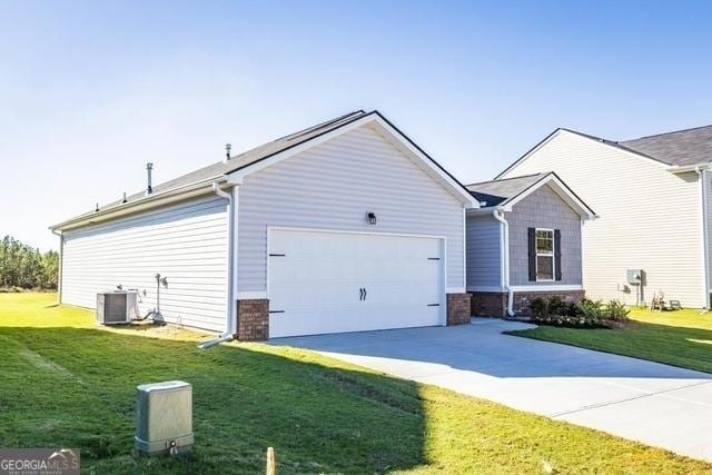 view of side of home with a lawn, central AC unit, and a garage