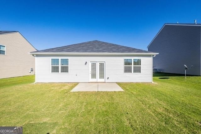 rear view of property featuring a patio and a lawn