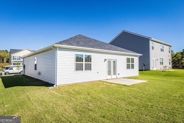 rear view of property with a lawn and a patio area