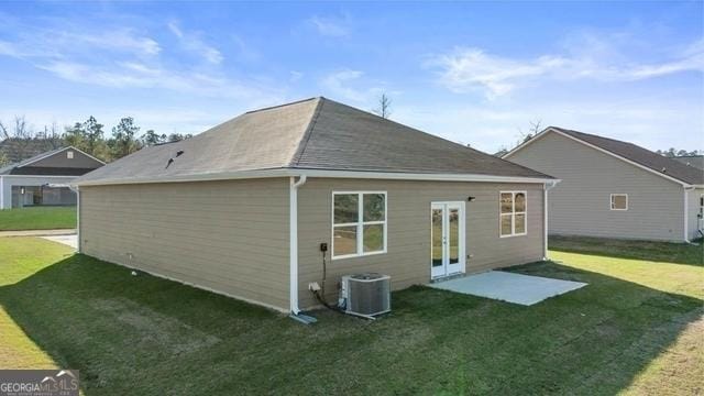 rear view of property with a lawn, french doors, and central AC unit