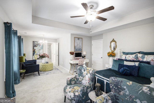 living room with ceiling fan with notable chandelier, carpet flooring, and a tray ceiling