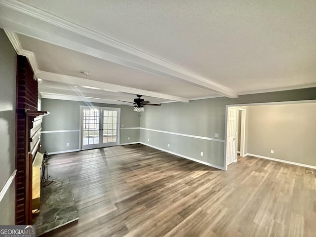 unfurnished living room with a fireplace, beamed ceiling, french doors, ceiling fan, and hardwood / wood-style flooring