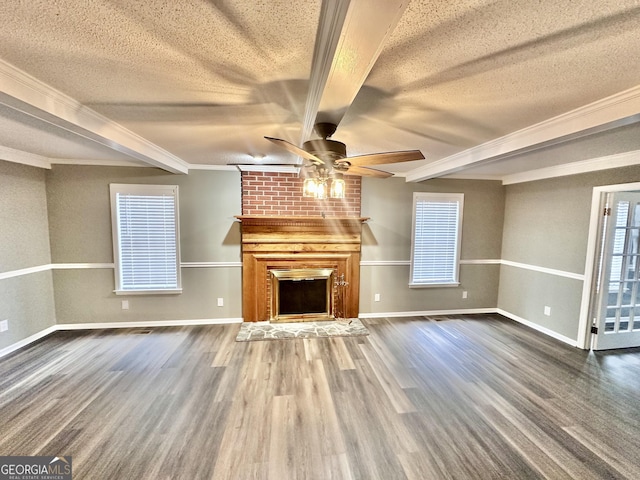 unfurnished living room featuring ornamental molding, beamed ceiling, a textured ceiling, and a fireplace