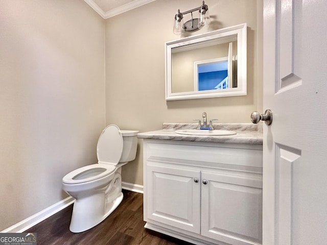 bathroom featuring toilet, hardwood / wood-style flooring, crown molding, and vanity