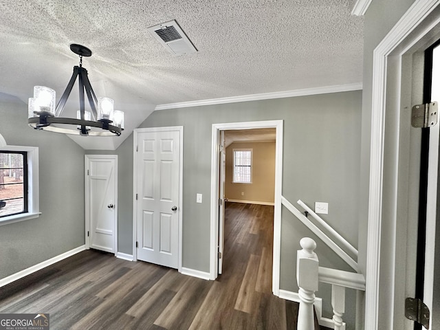 interior space featuring vaulted ceiling, a textured ceiling, a notable chandelier, and dark hardwood / wood-style floors