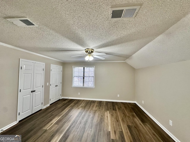 additional living space with ceiling fan, lofted ceiling, dark hardwood / wood-style floors, and a textured ceiling