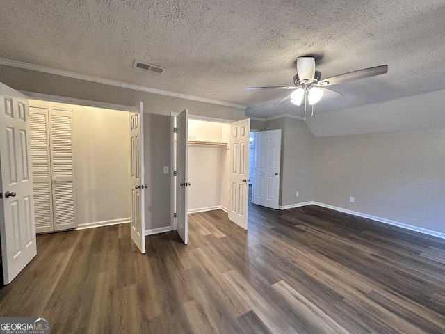 unfurnished bedroom with vaulted ceiling, crown molding, ceiling fan, dark wood-type flooring, and a textured ceiling