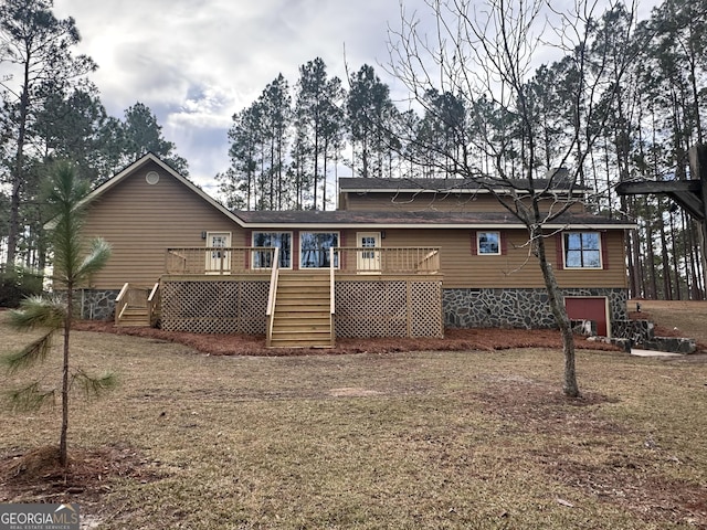 back of property with a yard and a wooden deck