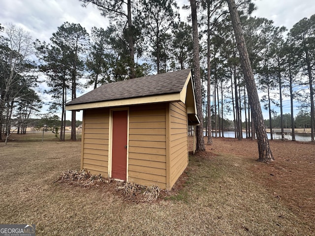 view of outdoor structure with a yard and a water view