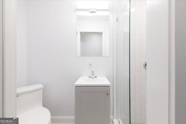 bathroom with walk in shower, vanity, and toilet