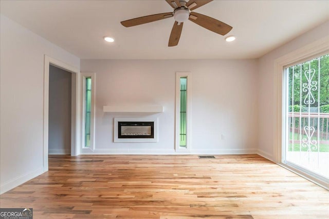 unfurnished living room with ceiling fan and light wood-type flooring