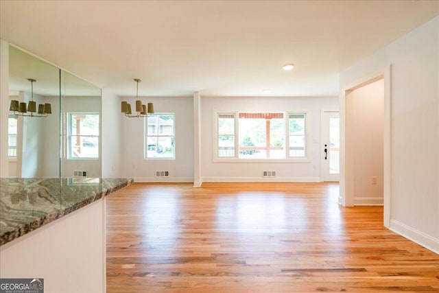 interior space with a chandelier and light hardwood / wood-style floors