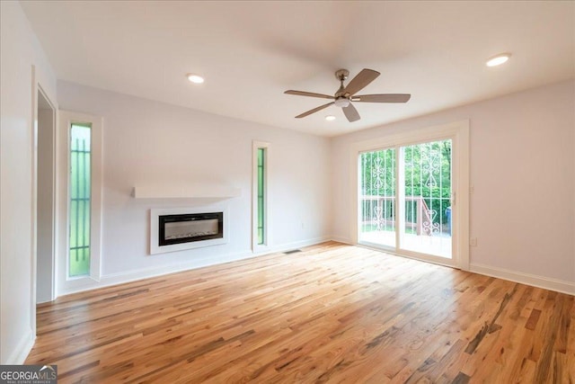 unfurnished living room featuring ceiling fan and light wood-type flooring