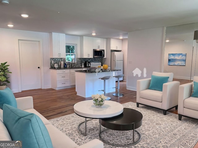 living room featuring sink and light hardwood / wood-style floors