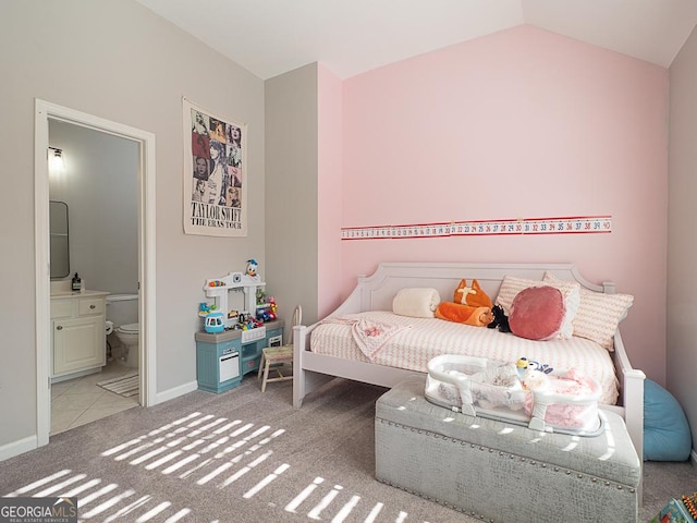 bedroom featuring lofted ceiling, ensuite bath, and carpet floors