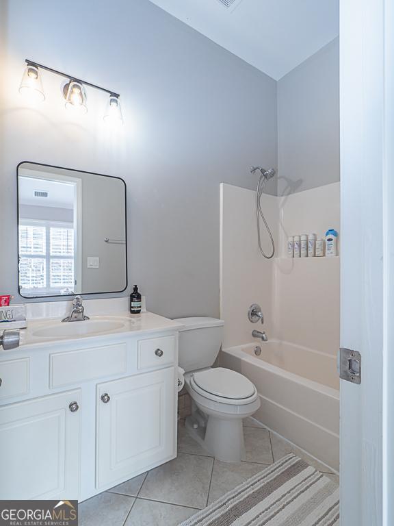 full bathroom featuring vanity, tile patterned flooring, toilet, and shower / tub combination